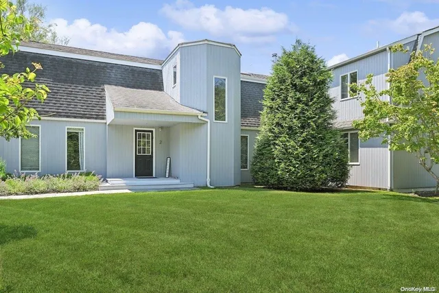 a front view of a house with a garden and yard