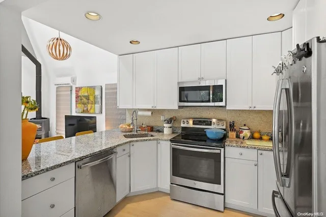 a kitchen with stainless steel appliances granite countertop a stove a sink and a refrigerator