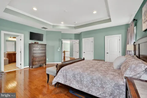 a spacious bedroom with a bed and wooden floor