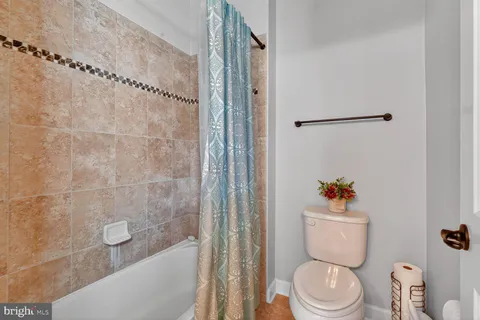 a white toilet sitting next to a bath tub