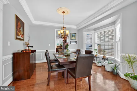 a dining room with furniture a chandelier and wooden floor