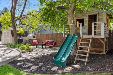 a backyard of a house with barbeque oven table and chairs