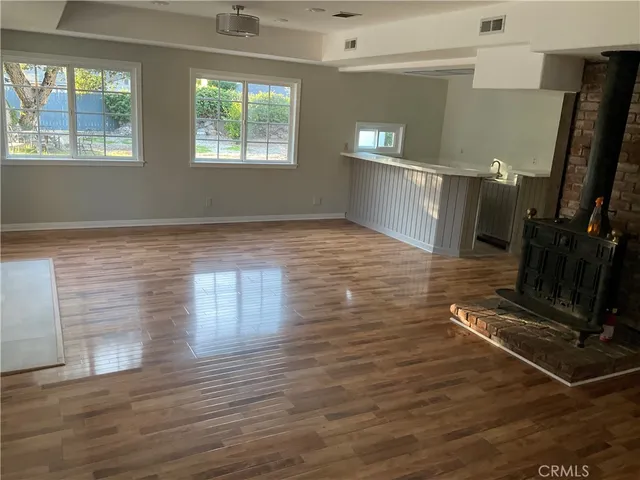 a view of a room with gym equipment and wooden floor
