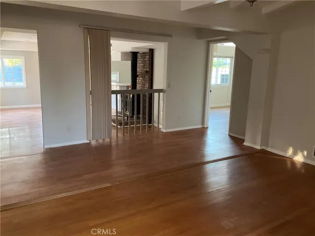 an empty room with wooden floor and a window