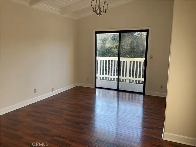 a view of a room with wooden floor and a window