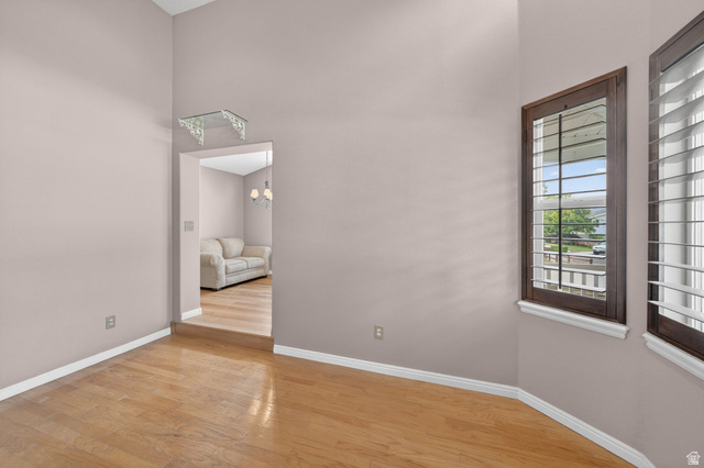 1464 990 West Provo, UT 84601 - Photo 6 of 41 Room featuring natural wood-finish flooring, vaulted ceilings, and a bay window with dark wood framing and plantation shutters