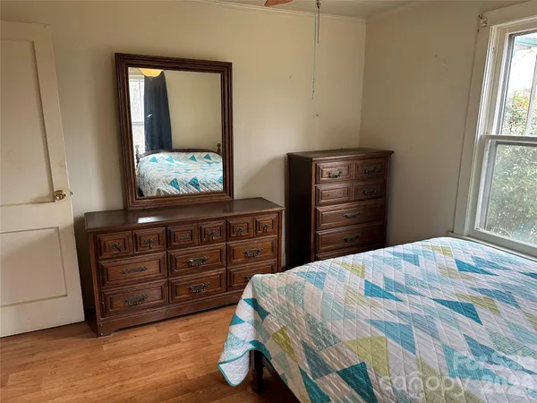 a bedroom with a bed dresser and a window