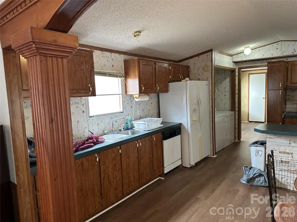 a kitchen with stainless steel appliances granite countertop a refrigerator a stove and a sink