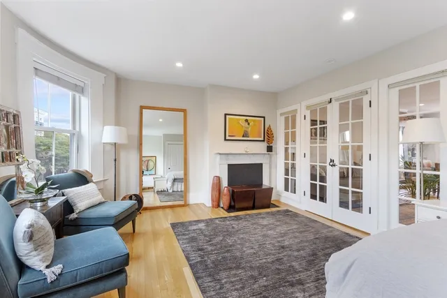 a living room with furniture a fireplace and a large window