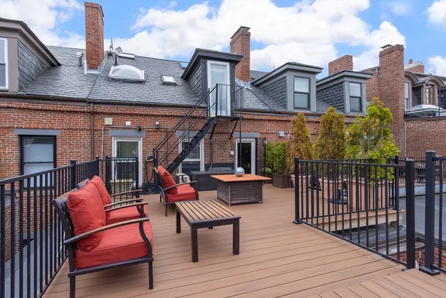 a view of a patio with couches table and chairs and wooden floor