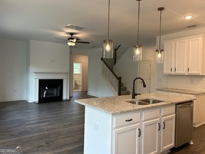 517 Principal Meridian Drive, Unit 22 Dallas, GA 30132 - Photo 2 of 17 a kitchen with a sink chandelier and a fireplace