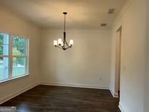 a view of empty room with wooden floor and windows