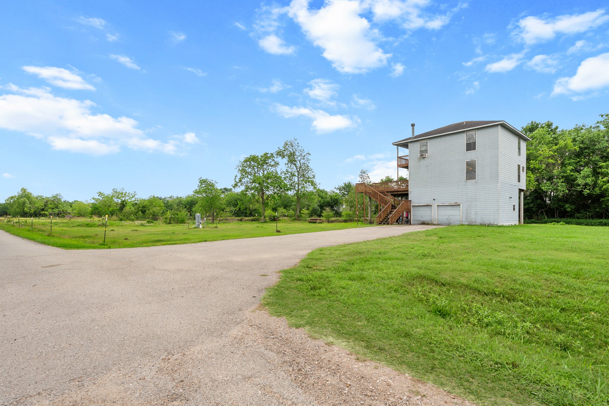 13803 Norris Road Rosharon, TX 77583 - Photo 15 of 20 a view of a white house with a big yard plants and large trees
