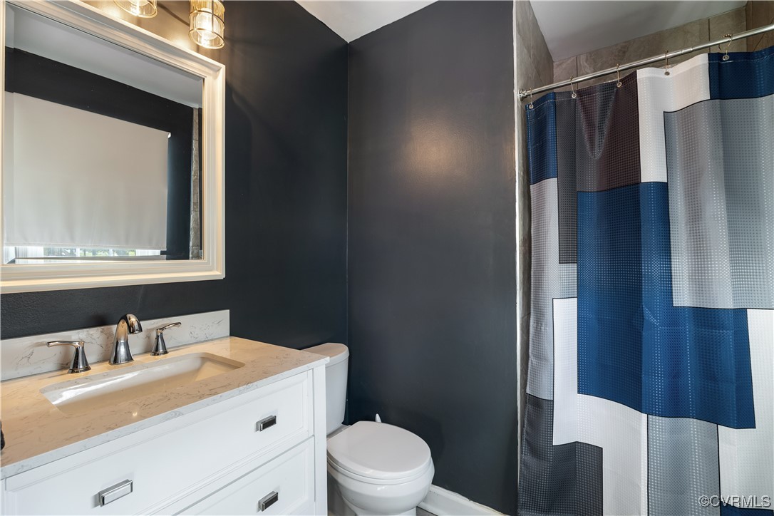 204 Pine Street Jarratt, VA 23867 - Photo 16 of 25 Full bathroom featuring vanity, toilet, and curtai