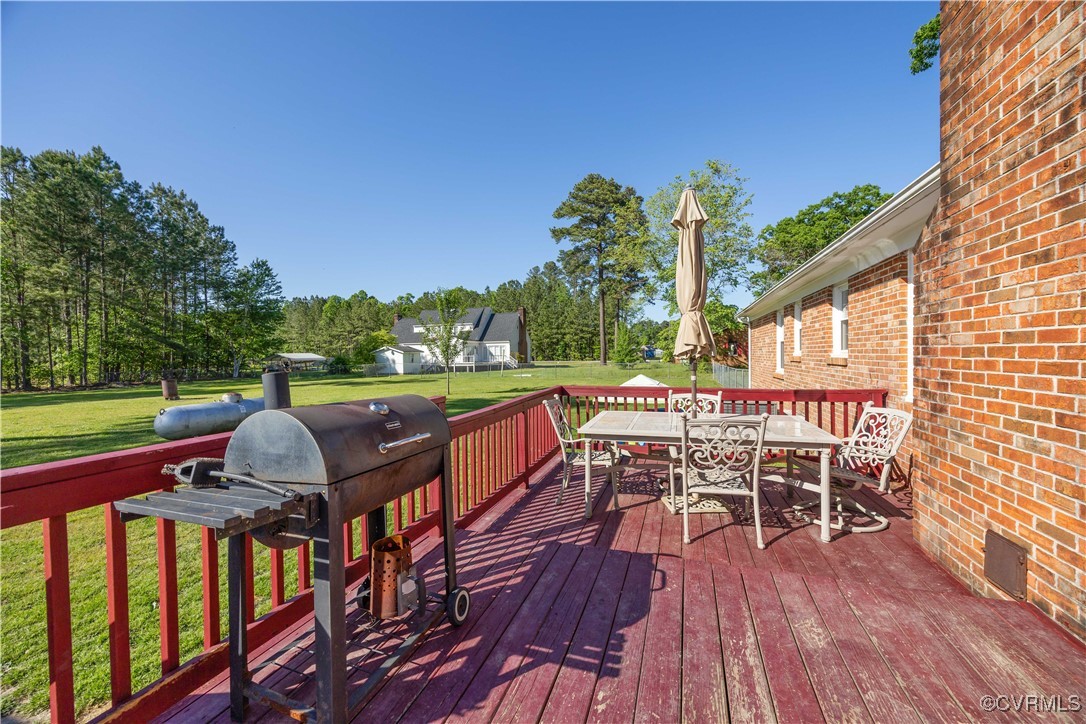 204 Pine Street Jarratt, VA 23867 - Photo 23 of 25 Deck with outdoor dining space, a yard, and grilli