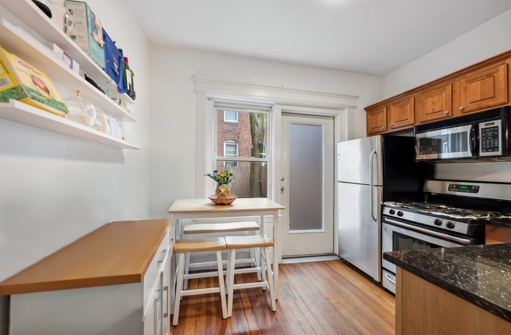 221 Shurtleff Street, Unit 1 Chelsea, MA 02150 - Photo 7 of 16 a kitchen with a table chairs refrigerator and a window