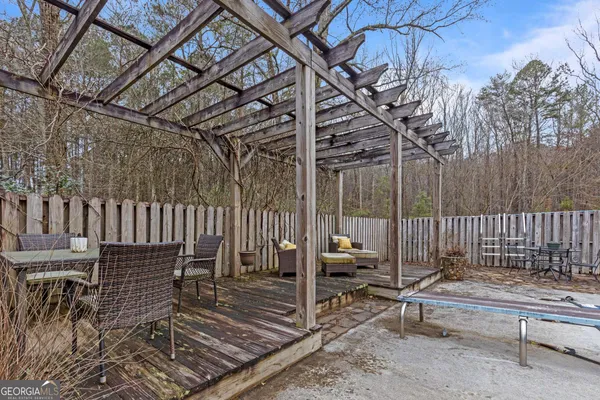a view of backyard with deck and outdoor seating