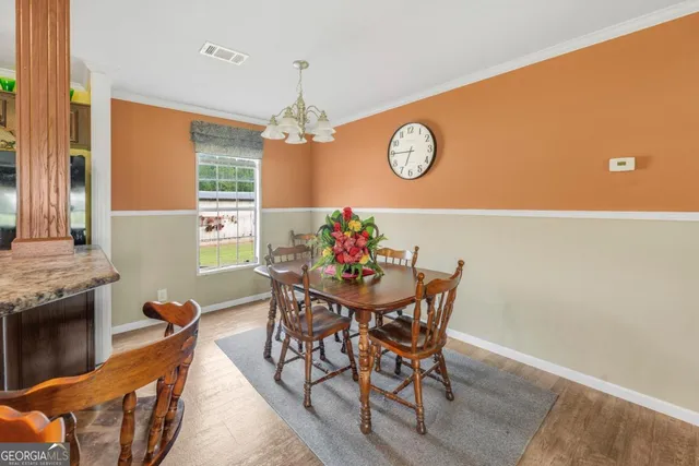 a view of a dining room with furniture and a chandelier