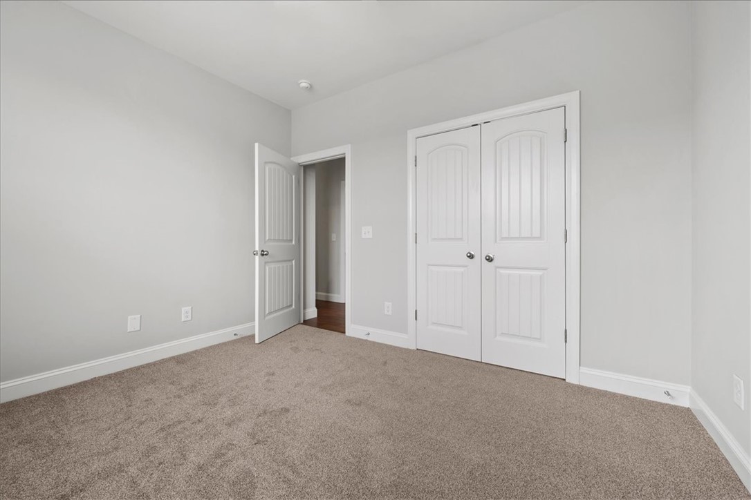 102 Ripplestone Way Anderson, SC 29621 - Photo 15 of 39 A well-lit bedroom features plush carpeting and white trim, ready for personalization.