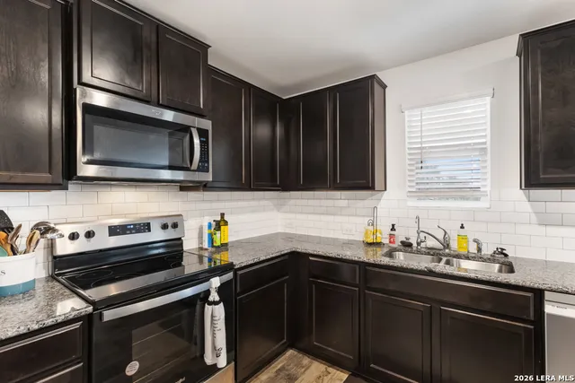 a kitchen with stainless steel appliances a sink dishwasher stove microwave and cabinets