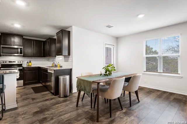 a kitchen with a table chairs refrigerator and microwave