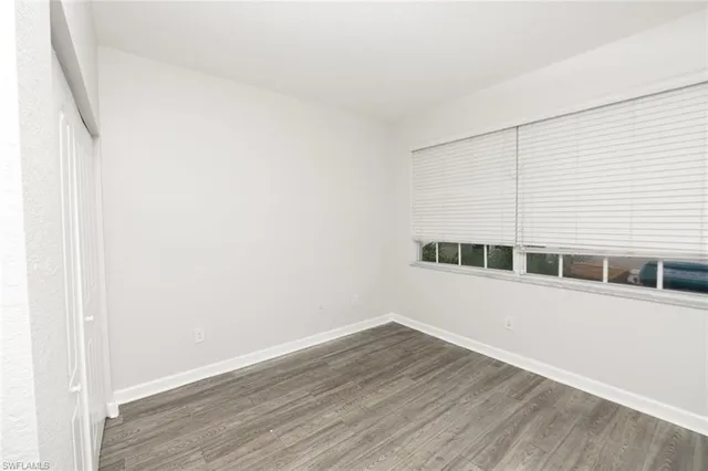 a view of a big room with wooden floor and windows