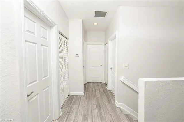 a view of a hallway with wooden floor