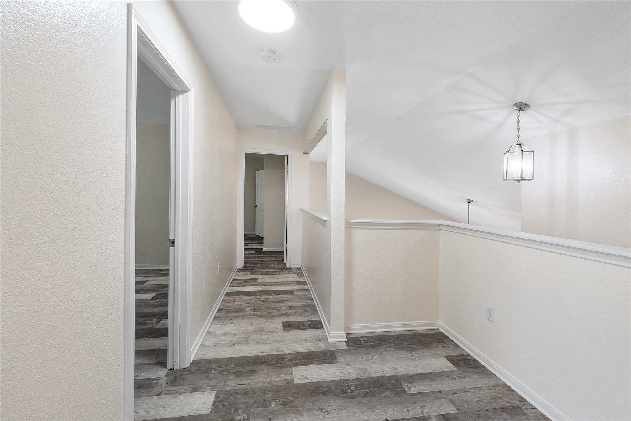 18436 Weatherby Lane Elgin, TX 78621 - Photo 16 of 23 Hallway with light wood-type flooring, an upstairs landing, and vaulted ceiling