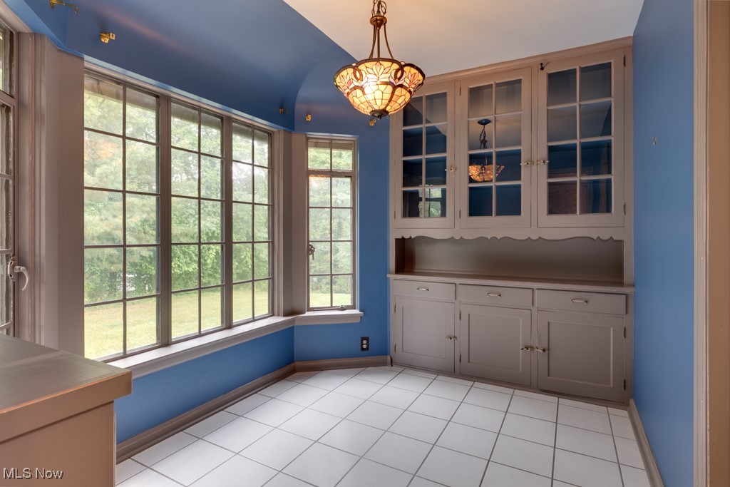569 Merriman Road Akron, OH 44303 - Photo 18 of 43 Unfurnished dining area featuring light tile patterned floors and a notable chandelier