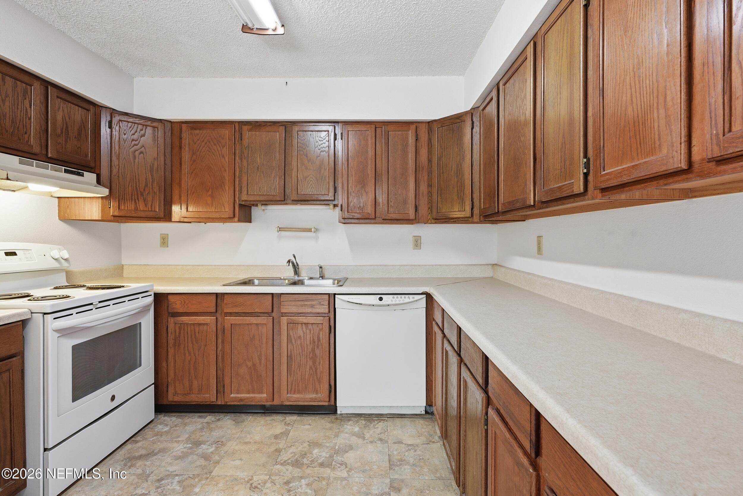 7593 Silver Sands Road Keystone Heights, FL 32656 - Photo 11 of 36 a kitchen with a sink stove and cabinets