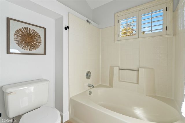 a spacious bedroom with a bed couch and a window