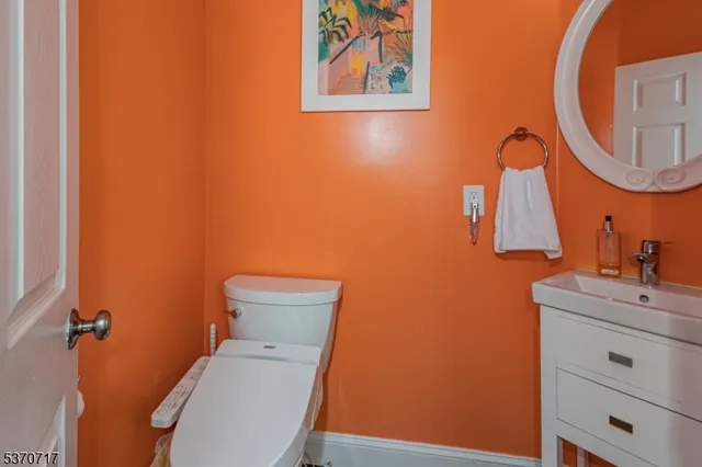 a bathroom with a toilet sink vanity and mirror