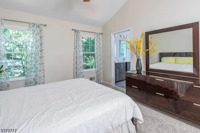 a bedroom with a bed and large windows