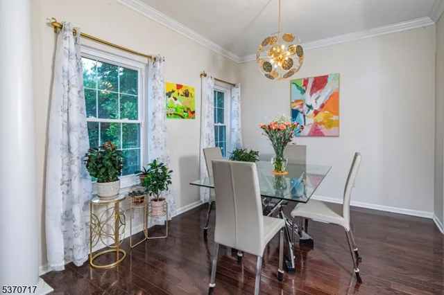 a view of a dining room with furniture a chandelier and wooden floor