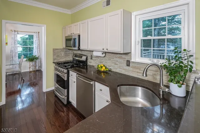 a kitchen with stainless steel appliances granite countertop a stove a sink dishwasher a microwave oven with granite countertops and cabinets