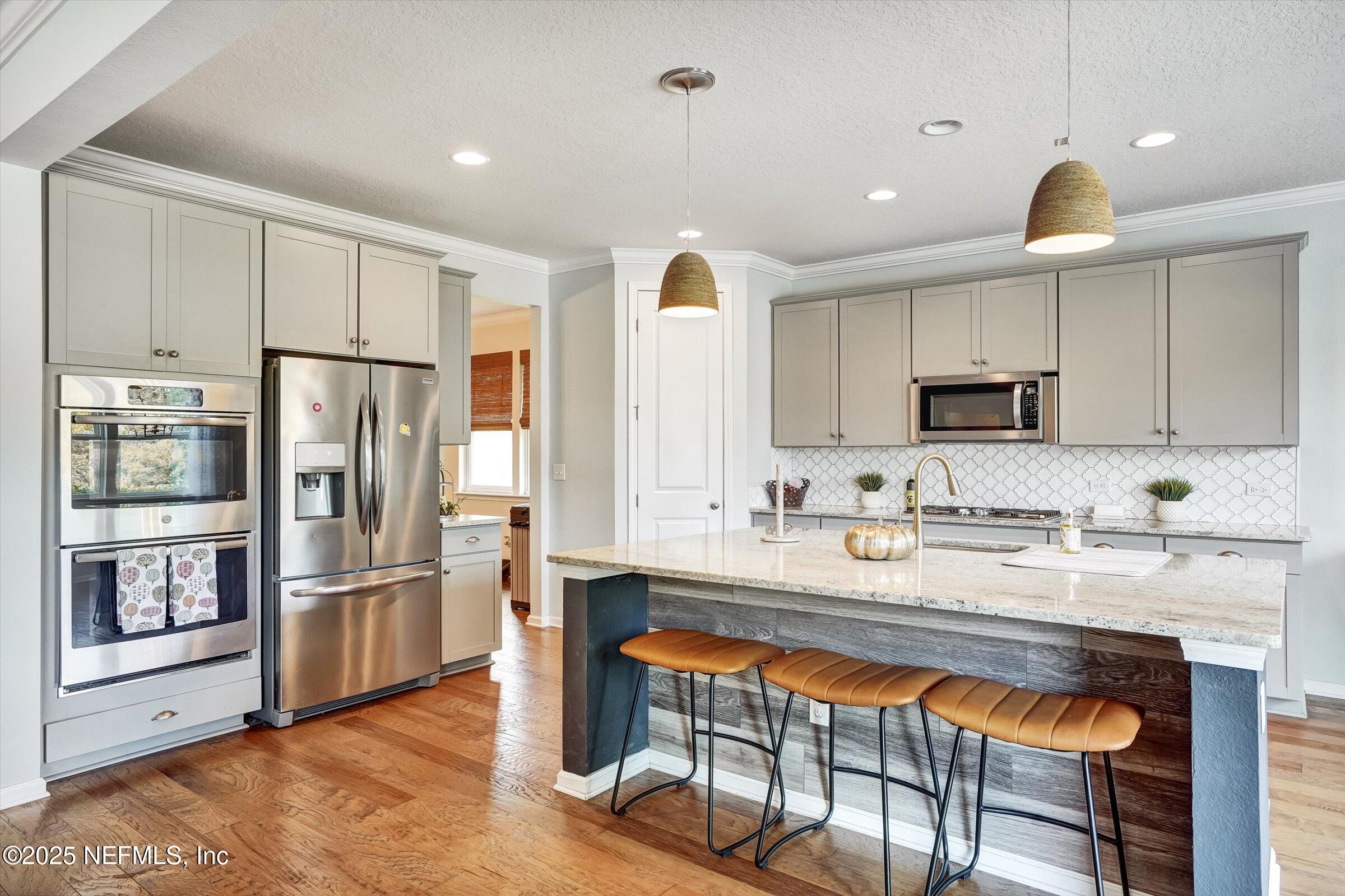 410 Downs Corner Road St. Augustine, FL 32092 - Photo 11 of 45 a kitchen with stainless steel appliances granite countertop a refrigerator and a stove top oven