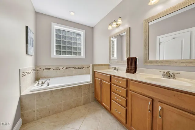 a bathroom with a tub sink and mirror