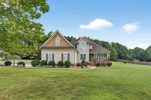 a front view of a house with a yard and trees