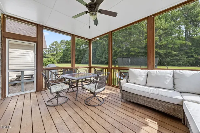 a living room with furniture and a large window with wooden floor