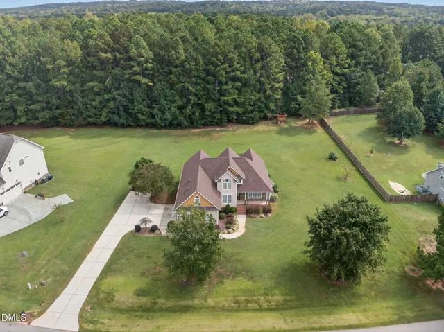 an aerial view of a house with a garden and lake view