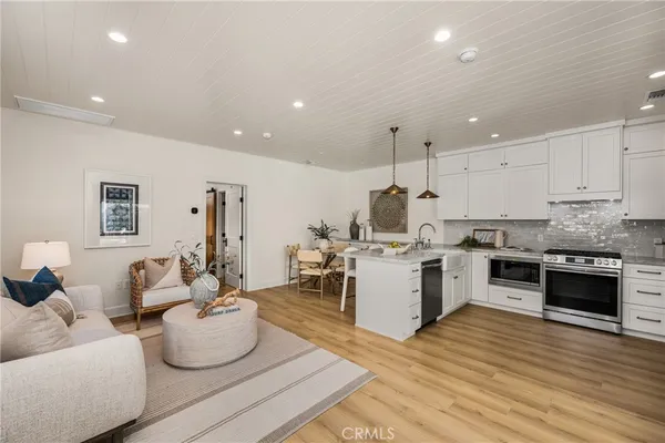 a open kitchen with stainless steel appliances kitchen island granite countertop a stove and white cabinets