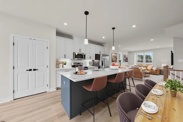 a living room with lots of furniture and kitchen view