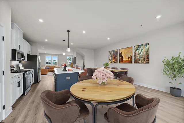 a living room with furniture kitchen view and a potted plant