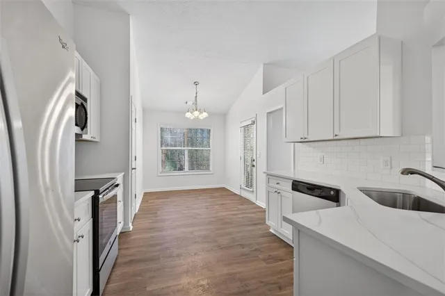 a kitchen with white cabinets and refrigerator