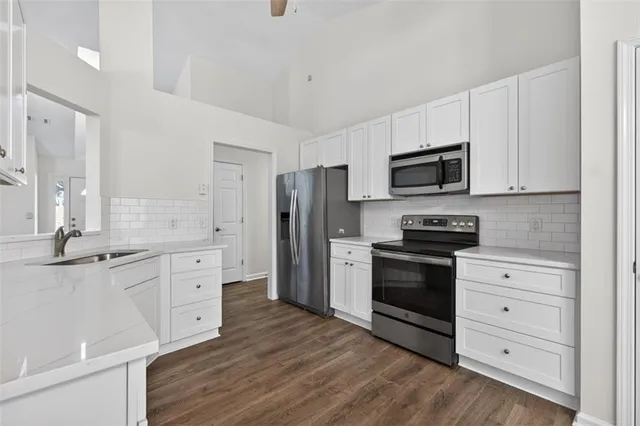 a kitchen with stainless steel appliances a stove a sink and a refrigerator