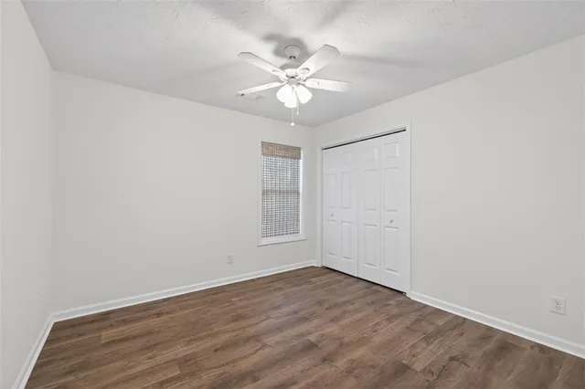 a view of a room with wooden floor and a ceiling fan