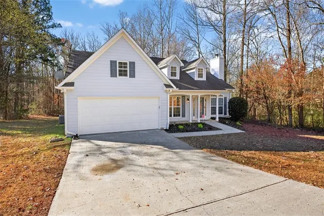 a view of a white house with a yard and large tree