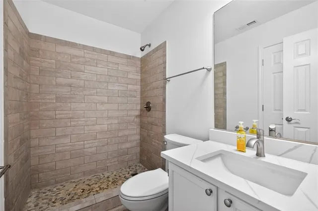 a bathroom with a sink a toilet and shower