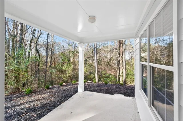 a spacious bedroom with a large window and a large tree