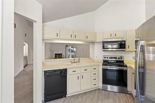 a kitchen with cabinets stainless steel appliances and wooden floor